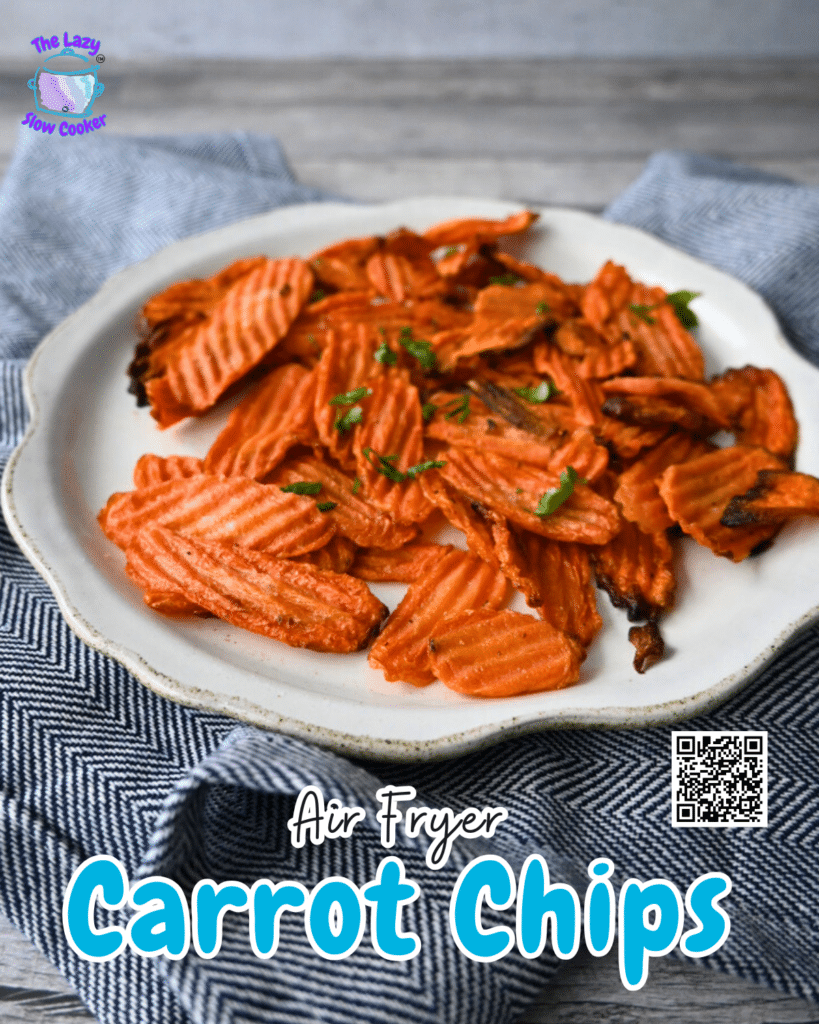 Crinkle-cut carrot chips topped with herbs are served on a white plate over a blue and white cloth. Text reads: Air Fryer Carrot Chips.