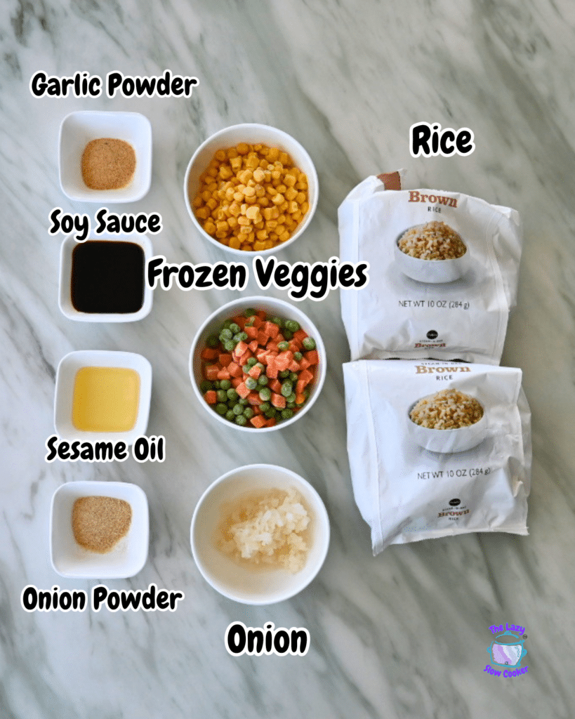 Ingredients for air fryer fried rice arranged on marble: small bowls of spices and sauces, chopped onion, veggies, and two rice packets.