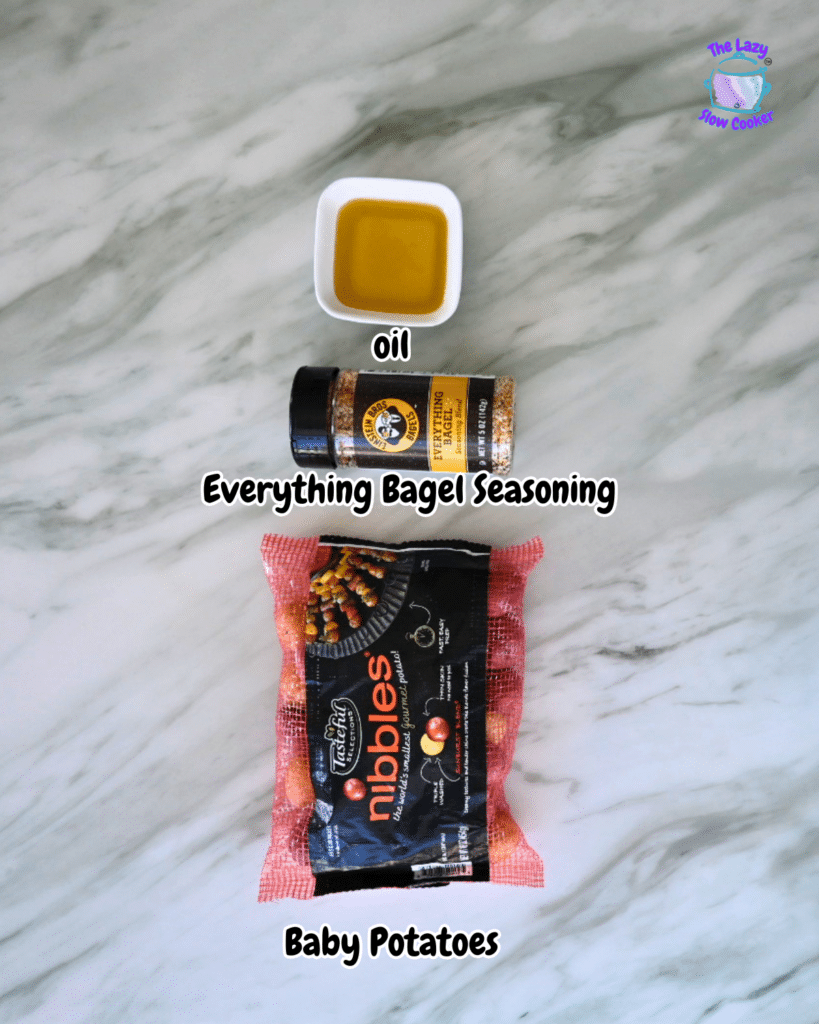 On a marble counter, oil in a small bowl, Everything Bagel Seasoning, and baby potatoes are labeled for air fryer potatoes.