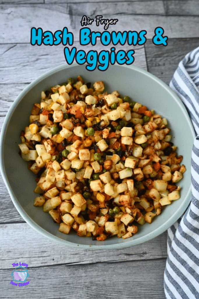 A bowl of air-fried hash browns with peas, carrots, and corn sits on wood by a striped cloth. Text reads Air Fryer Hash Browns & Veggies.
