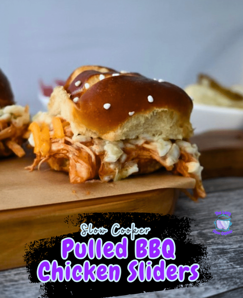 Three BBQ chicken sliders made in a slow cooker sit on pretzel buns with melted cheese, arranged on a wooden board. Text reads the recipe name.