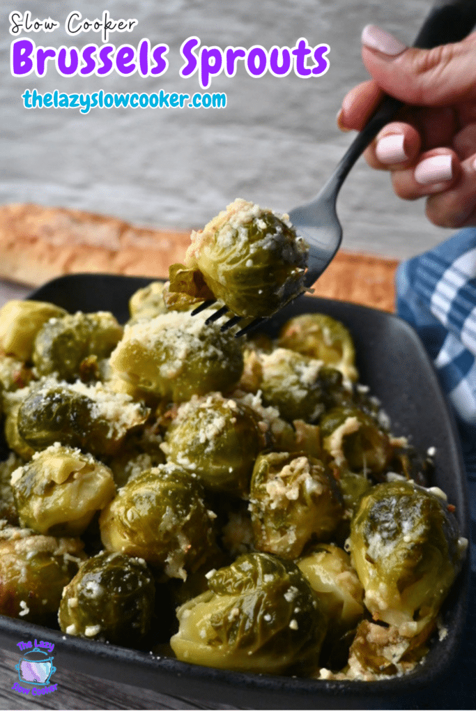 A hand lifts a cheesy Brussels sprout with a fork from a black dish of slow-cooked Brussels sprouts. Text: Slow Cooker Brussels Sprouts.