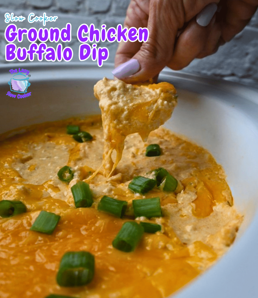 A hand dips a chip into a slow cooker filled with creamy buffalo dip made from ground chicken, garnished with chopped green onions. The words "Slow Cooker Ground Chicken Buffalo Dip" appear on the image.