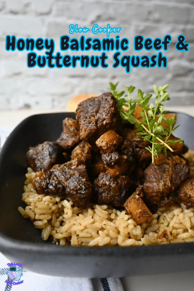 A black bowl holds slow-cooked honey balsamic beef and chunks of butternut squash on a bed of rice, topped with fresh herbs. Text above the bowl reads, “Slow Cooker Honey Balsamic Beef & Butternut Squash.”.