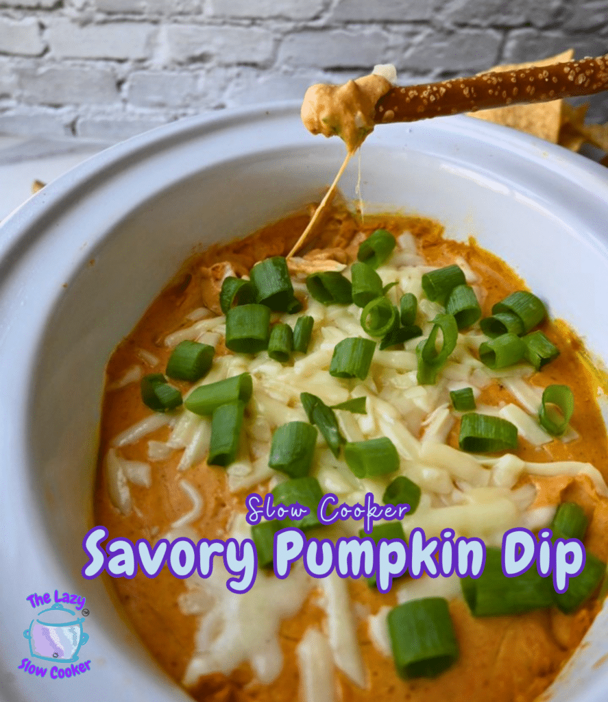 A white slow cooker holds orange savory pumpkin dip, topped with melted cheese and chopped green onions, with a pretzel stick dipped into the mixture. The text on the image says “Slow Cooker Savory Pumpkin Dip.”.