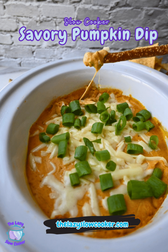 A bowl of warm pumpkin dip made in a slow cooker is topped with melted cheese and chopped green onions, with pretzels beside it for dipping. The image includes the text: Slow Cooker Savory Pumpkin Dip and thelazyslowcooker.com.